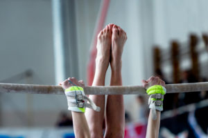 hands and feet young girl gymnast exercises on bar